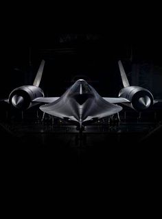 a fighter jet sitting on top of an airport tarmac in the dark at night