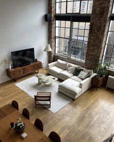 a living room filled with furniture and large windows