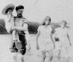 an old black and white photo of people walking in the water with hats on their heads