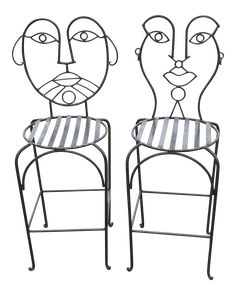 two metal chairs with faces on them