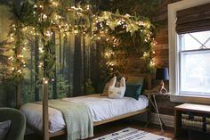 a bedroom decorated for christmas with lights and greenery on the wall above the bed