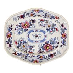 an ornately decorated platter with flowers and leaves on the rim, is shown