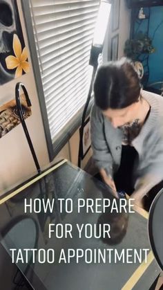 a woman sitting at a table in front of a window with the words how to prepare for your tattoo appointment