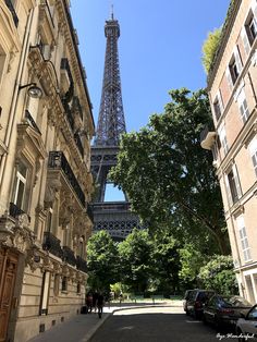 the eiffel tower towering over the city of paris, france as seen from between two buildings