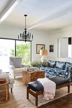 a living room filled with furniture and a chandelier hanging over the top of it