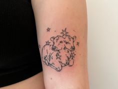 a woman's arm with a small tattoo of a sheep and stars on it