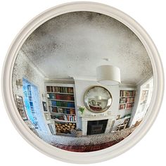 a mirror view of a living room with bookshelves and a fireplace in it