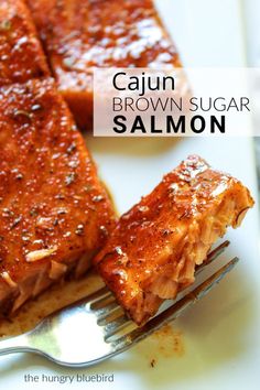 a piece of brown sugar salmon sitting on top of a white plate next to a fork