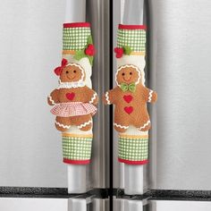 two gingerbreads are hanging from the handles of a refrigerator