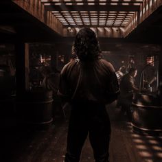 a man standing in the middle of a room filled with barrels