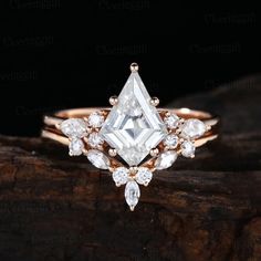 a white diamond ring sitting on top of a piece of wood