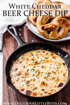 white cheddar beer cheese dip in a cast iron skillet with pretzels on the side