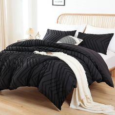 a bed with black and white comforters in a bedroom