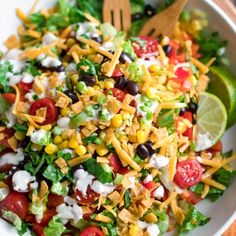 a salad with corn, tomatoes, lettuce and black olives