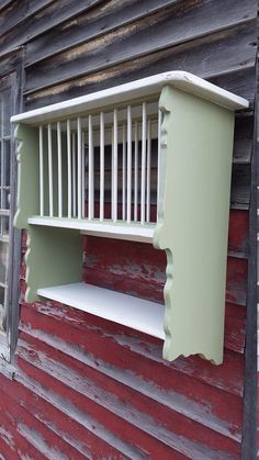 a white shelf sitting on the side of a red building