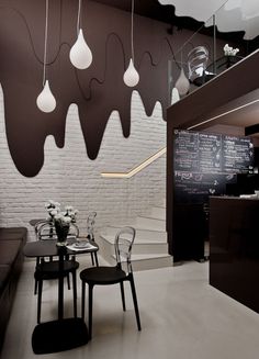 the interior of a restaurant with white brick walls and black chairs, chalkboard menus hanging from the ceiling