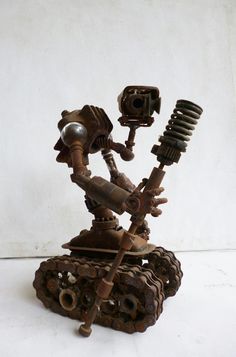 a sculpture made out of rusty objects on a white surface