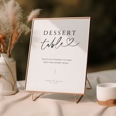 there is a sign that says dessert table next to two vases with flowers in them