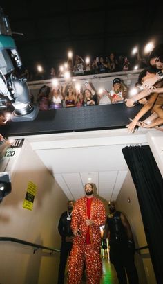 a man in an orange jumpsuit is surrounded by people