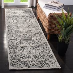 a large white rug with an intricate design on the floor in front of a window