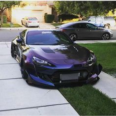 a purple sports car parked in front of a house