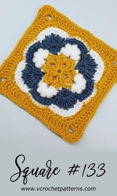 the square is crocheted and has blue, yellow and white flowers on it