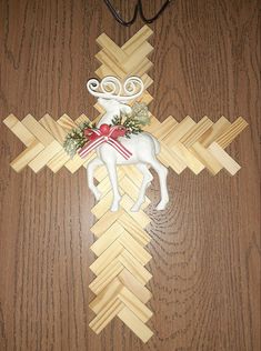 a cross made out of wood with a horse on it and christmas decorations hanging from the side