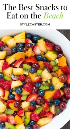 a white bowl filled with lots of different types of fruit on top of a wooden table