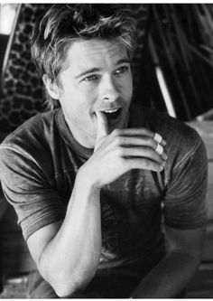 a black and white photo of a man brushing his teeth