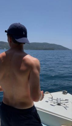 a shirtless man on a boat in the ocean