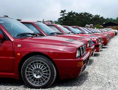 a row of red cars parked next to each other