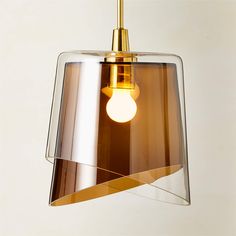 a light that is hanging from the ceiling with a glass shade on it's side