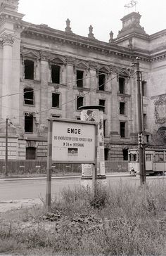 black and white photograph of an old building with a sign in front of it that says ende