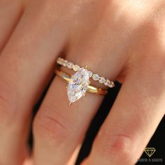 a woman's hand with a diamond ring on top of her finger and an engagement band