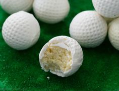 several white golf balls on a green surface