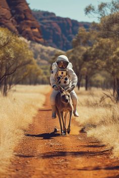 a man riding on the back of a horse down a dirt road