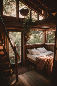a bed sitting under a window next to a stair case in a room with wooden floors