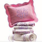 a stack of pillows and blankets with monogrammed letters on them