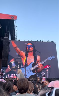 a large screen with an image of a man playing guitar on it's side