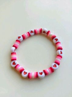a pink and white bracelet with hearts on it