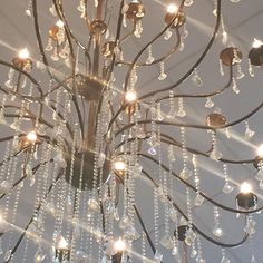 a chandelier hanging from the ceiling in a room with lights all around it