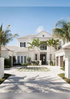 a large white house surrounded by palm trees