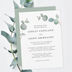 a wedding card with eucalyptus leaves on it