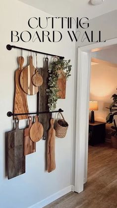 a wall mounted rack with cutting boards and utensils hanging from it's sides