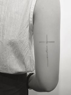 a person with a cross tattoo on their arm