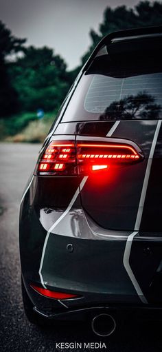the tail light of a black car with white lines on it