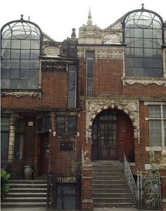 an old brick building with lots of windows on the front and back of it's facade