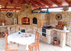 an outdoor kitchen with stone oven and table