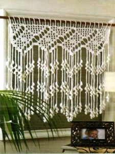 an image of a white crocheted curtain hanging from a window with the word, visitar on it