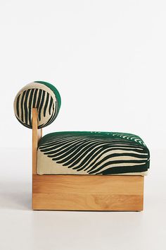 a wooden bed with a green and white pillow on it's headrest, in front of a white background